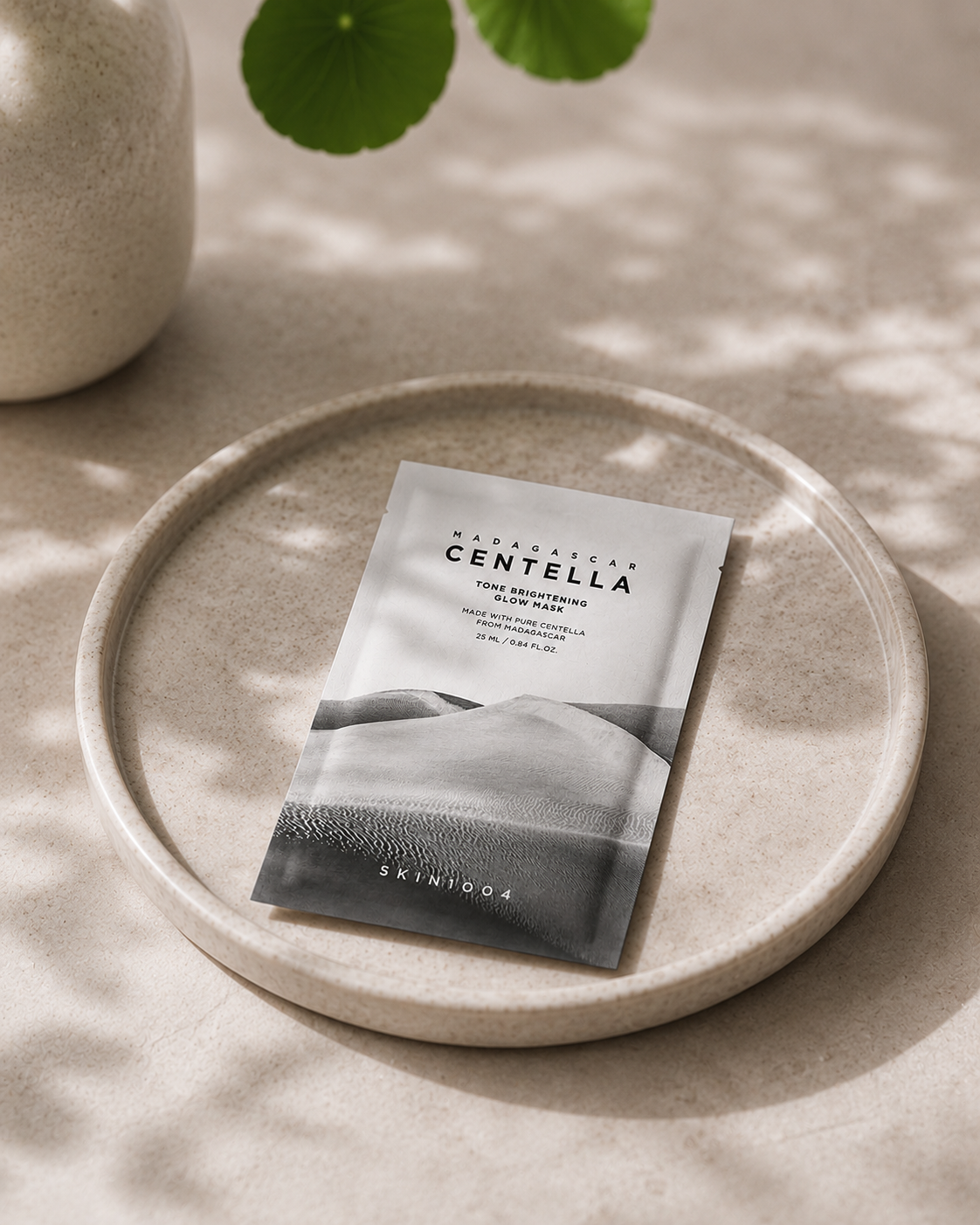 Skintoga Centella product packaging on a beige plate with a plant in the background