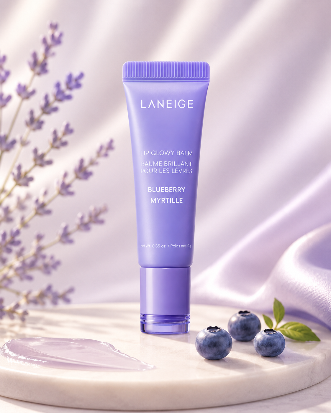 Laneige Lip Glowy Balm Blueberry displayed in a soft lavender-inspired setting with fresh blueberries and botanical accents, highlighting its moisturizing formula. This nourishing Korean lip balm provides intense hydration, enhances natural lip shine, smooths dry lips, and leaves them feeling soft, supple, and healthy with a refreshing blueberry fragrance.