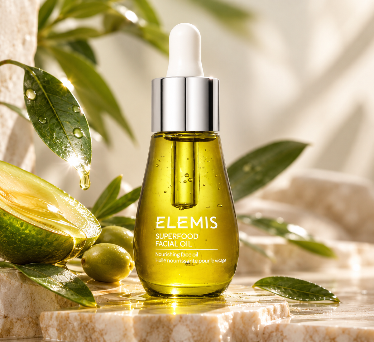ELEMIS Superfood Facial Oil, a nourishing skincare treatment in an elegant glass dropper bottle filled with golden oil, surrounded by fresh green olives, botanical leaves and natural oils. A luxurious lightweight facial oil designed to hydrate, nourish and soften skin for a healthy, radiant complexion.