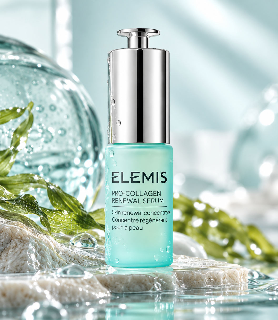 ELEMIS Pro-Collagen Renewal Serum in a turquoise bottle with a silver pump, elegantly displayed on natural stone surrounded by fresh green leaves, water droplets and crystal-clear reflections. Luxurious anti-aging facial serum that helps smooth fine lines, improve skin firmness and promote a radiant, youthful-looking complexion.
