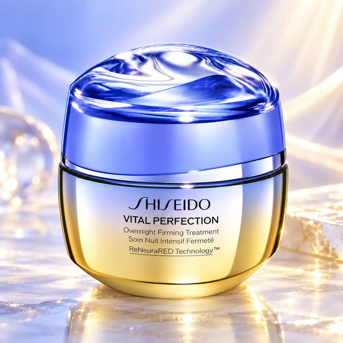 Shiseido Vital Perfection Overnight Firming Treatment in a luxurious gold jar with a luminous blue lid, displayed on a reflective marble surface with soft lavender and champagne tones, elegant glass accents and warm golden lighting. Premium Japanese overnight firming and anti-aging skincare.