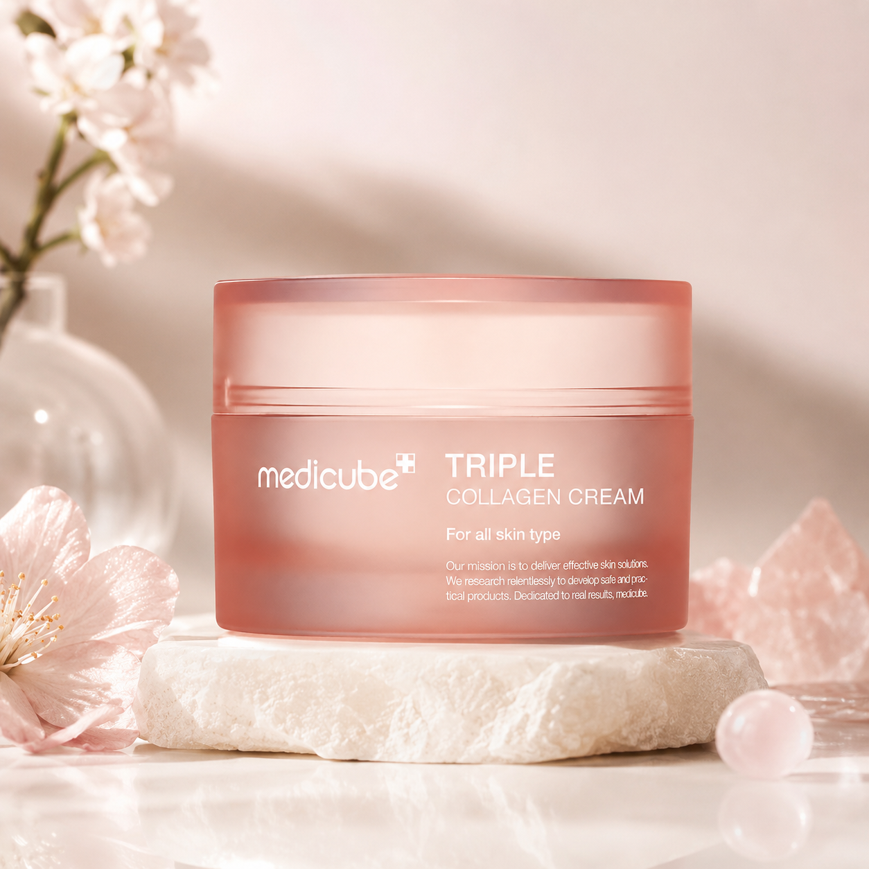Medicube Triple Collagen Cream 4.0 50ml on a white surface with flowers and crystals in the background
