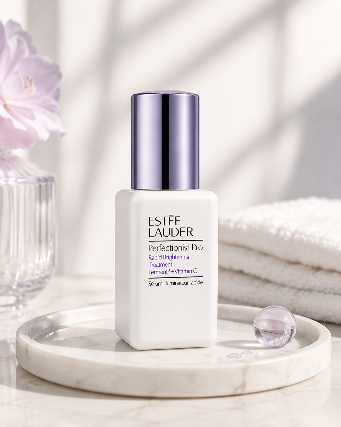 Estée Lauder Perfectionist Pro Rapid Brightening Treatment Ferment³ + Vitamin C elegantly displayed on a polished cream marble vanity tray in soft natural morning light. The composition features delicate lavender flowers in a ribbed glass vase, plush folded white spa towels, translucent serum droplets, a subtle glass sphere reflecting soft purple hues, and a luxurious minimalist skincare setting with creamy neutral tones. 